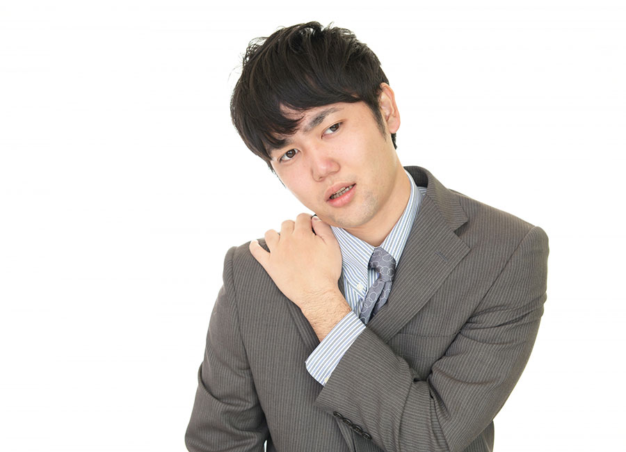 重い肩こりに悩む男性